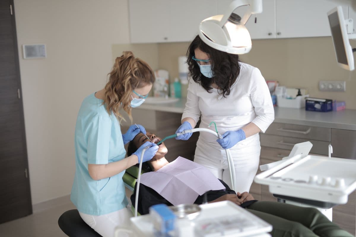 Two dental specialists treating a patient in a modern clinic